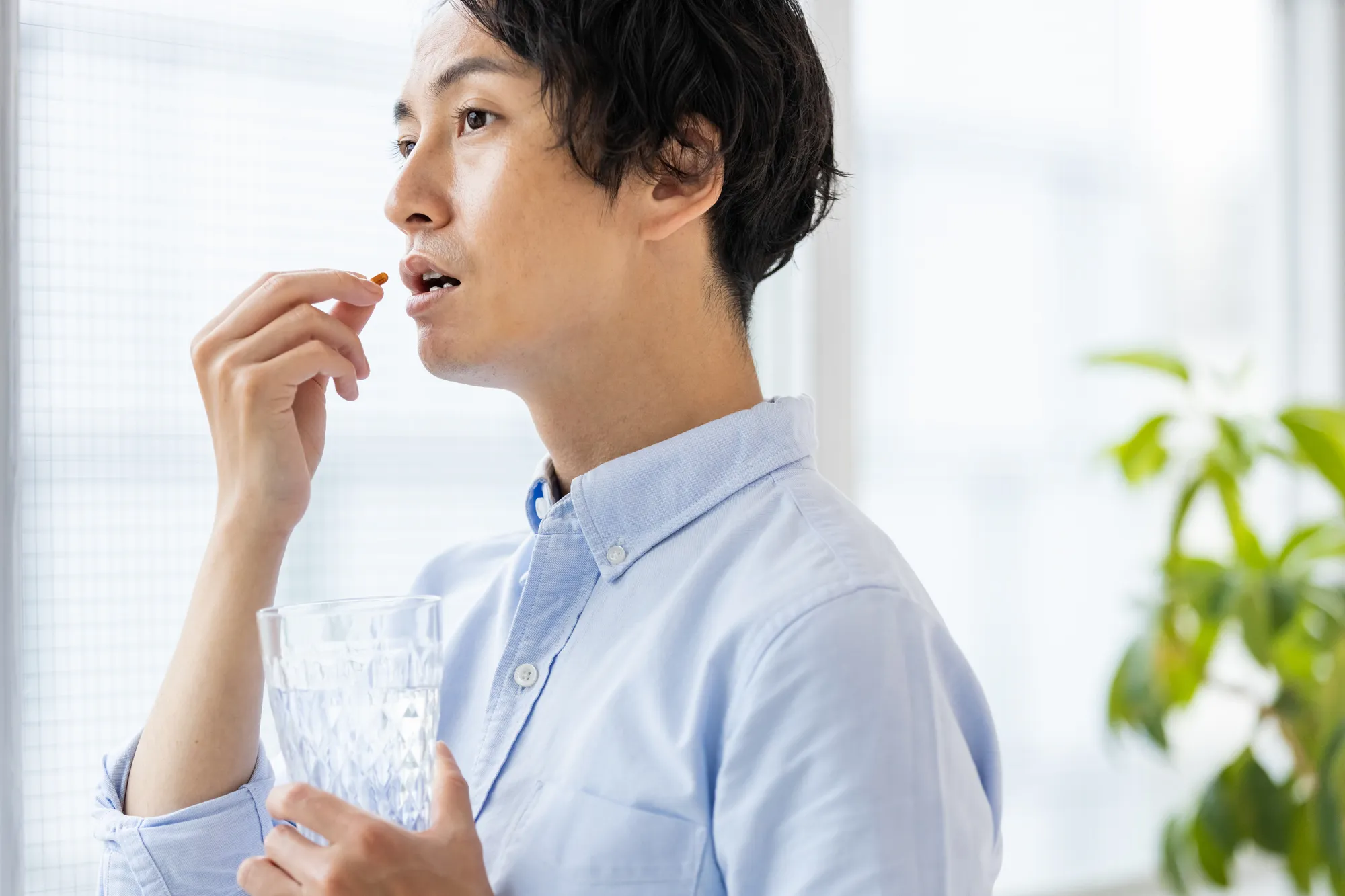 薬を飲む男性