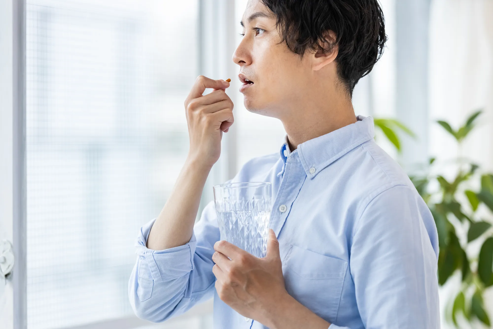 薬を飲む男性