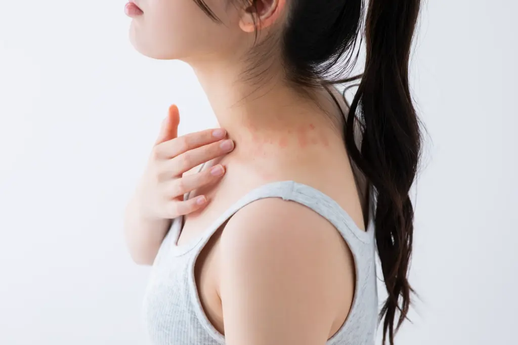 喉を押さえる女性