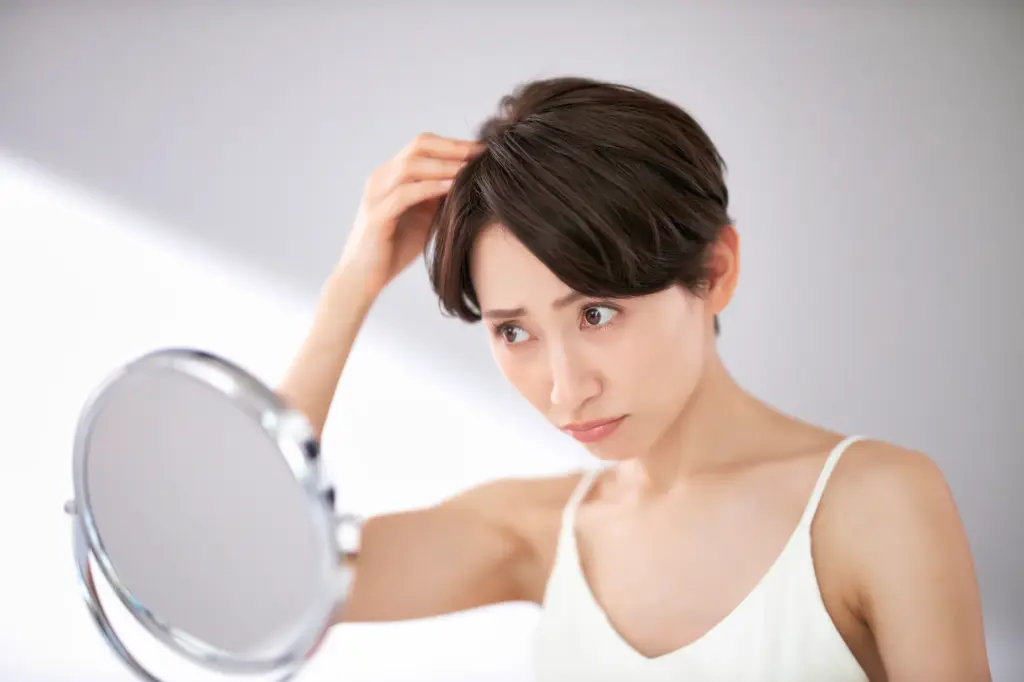 髪の毛を気にする女性